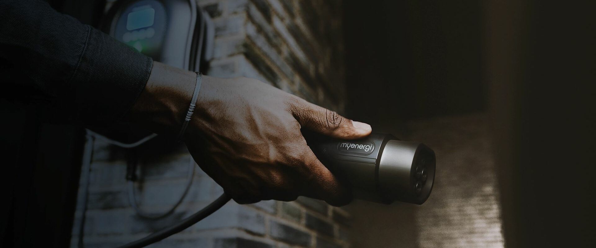 Hand plugging zappi into charging port of EV